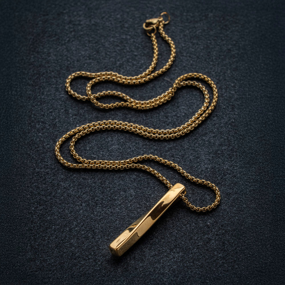 Gold necklace with a pendant on a dark textured background