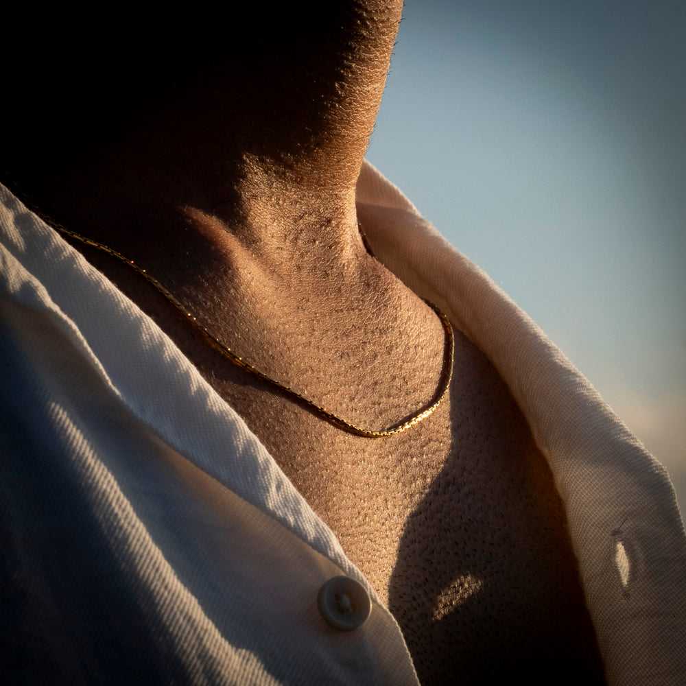 Close-up of a person wearing a wire chain gold