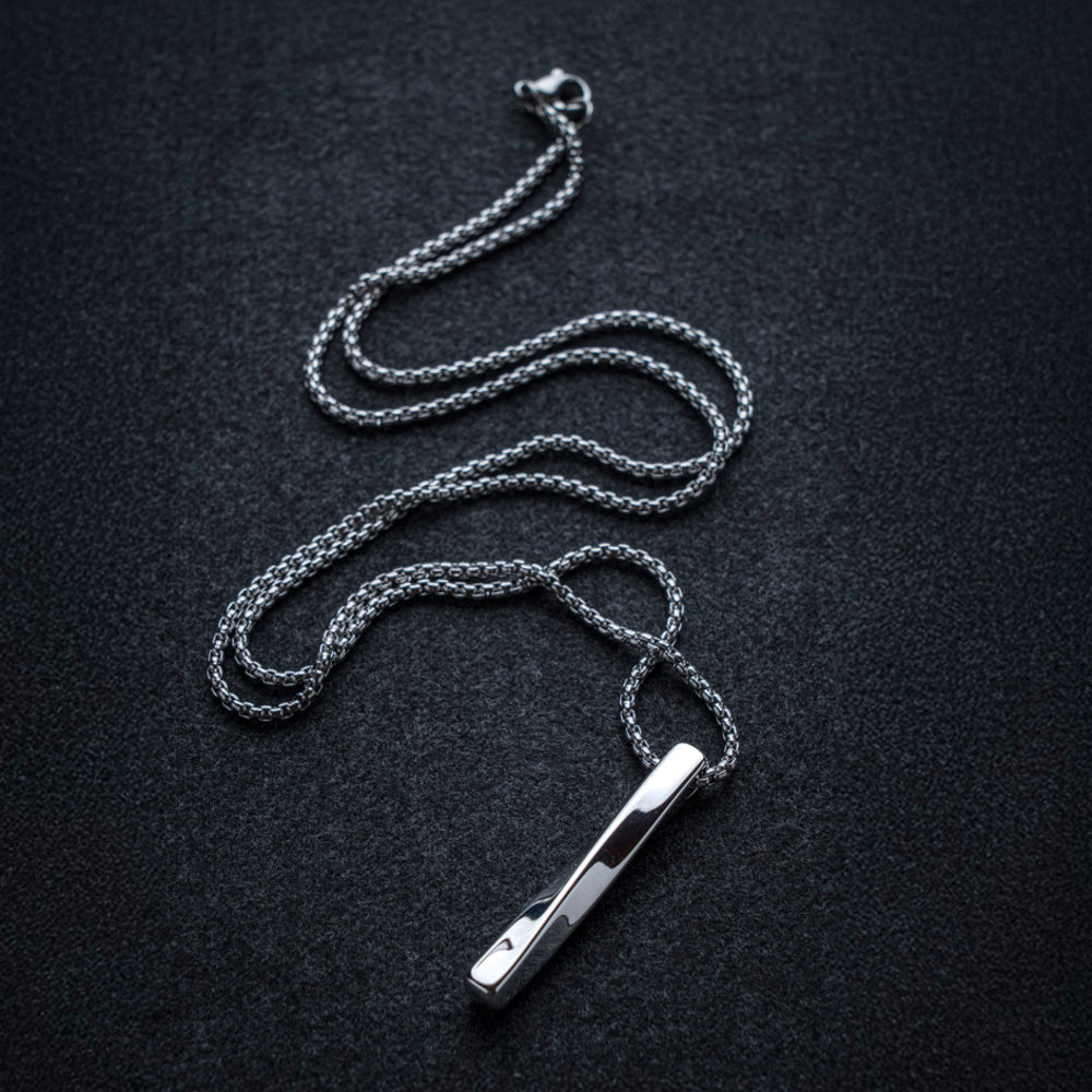 Silver chain necklace with a pendant on a black background