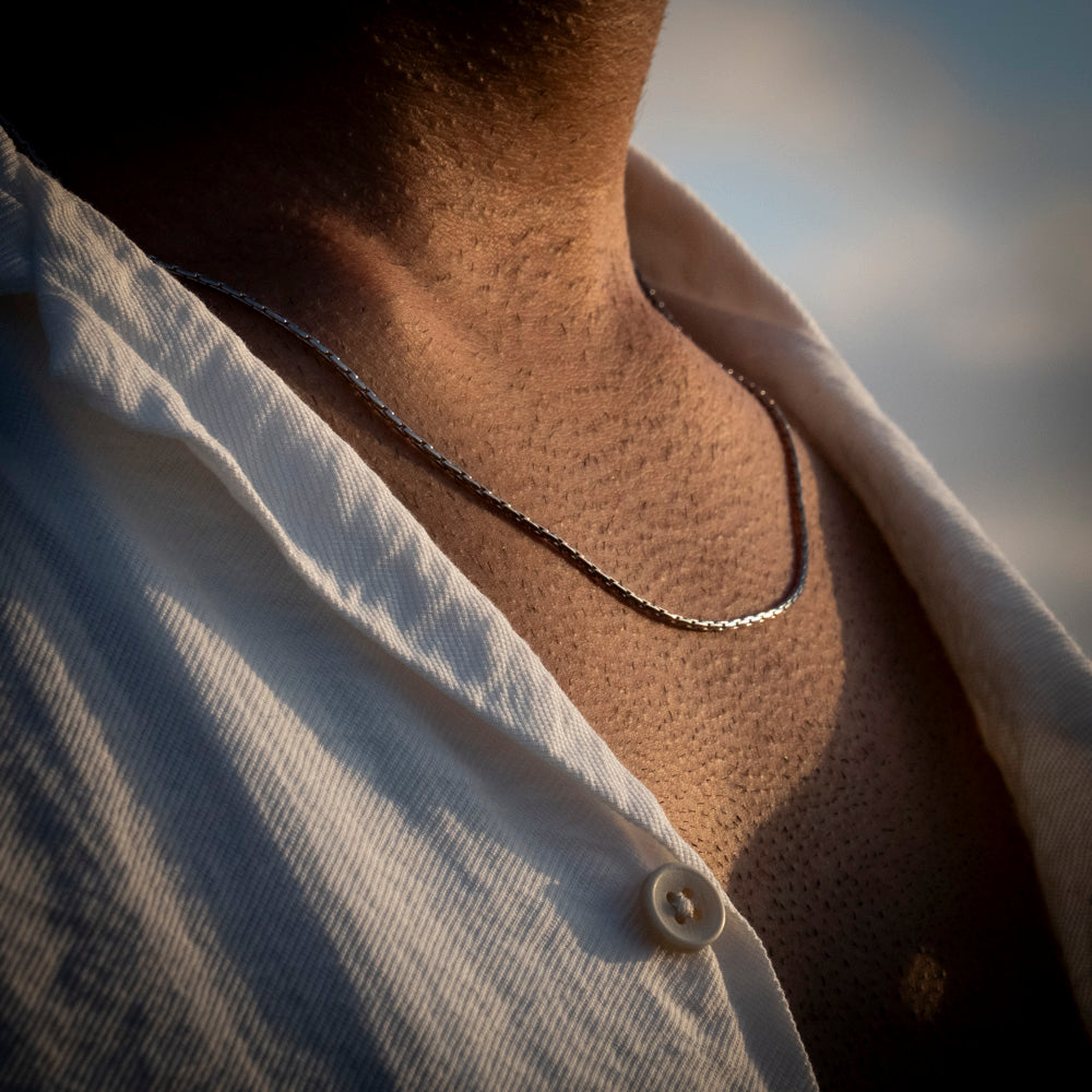 Close-up of a person wearing a necklace with a blurred background