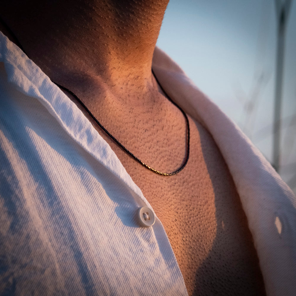 Close-up of a person wearing a wire chain black  with a blurred background